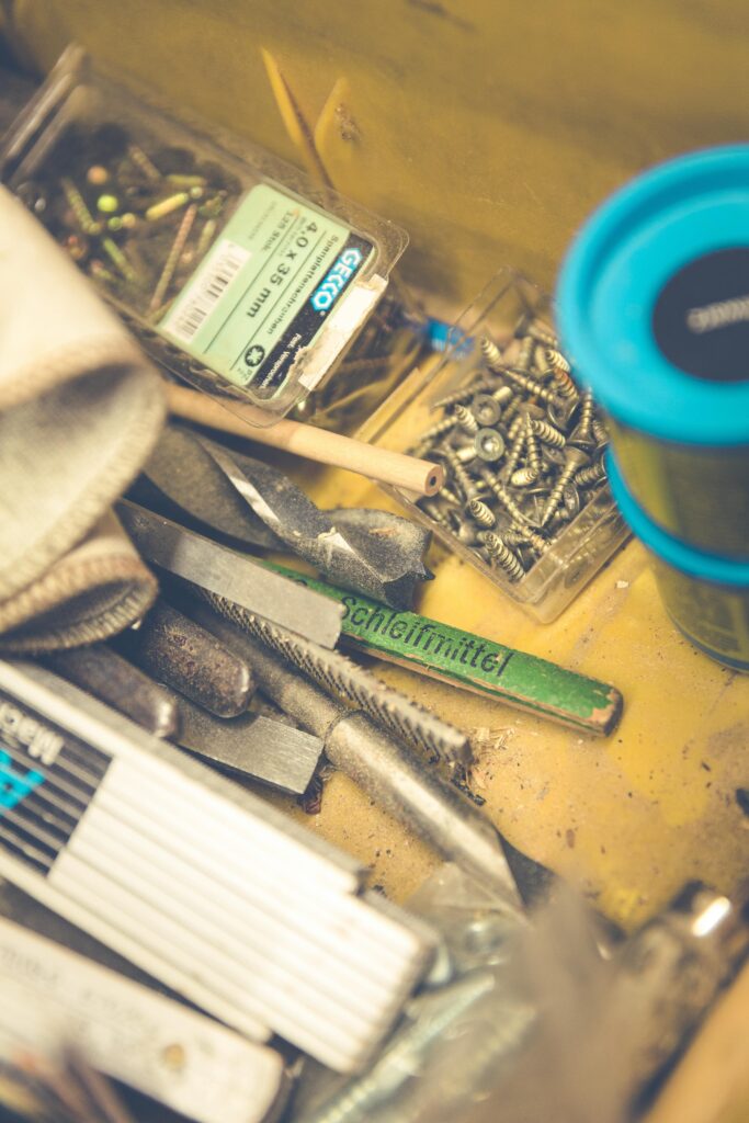 Close-up view of a toolbox with various screws, tools, and hardware supplies.